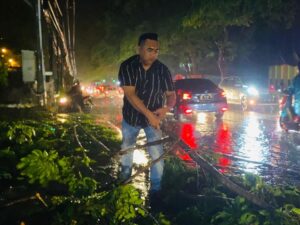 Aksi Kapolsek Muara Dua Bersama Masyarakat Evakuasi Pohon Tumbang Ganggu Arus Lalu Lintas.