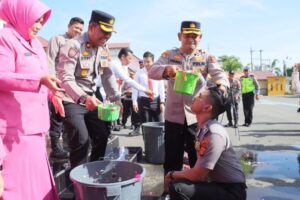 Kapolres Lhokseumawe AKBP Henki Ismanto, S.I.K menyiramkan bungka air bunga kembang sebagai motivasi dan wujud rasa syukur atas kenaikan pangkat personil Polres Lhokseumawe, senin (3/7/2023).