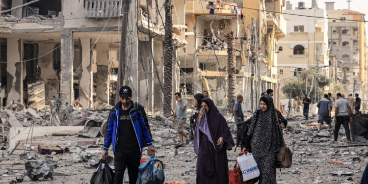 Palestinians leave al-Karama neighbourhood in Gaza City to safer areas on October 11, 2023, as raging battles between Israel and the Hamas movement continued for the fifth consecutive day.  (Photo by MAHMUD HAMS / AFP)