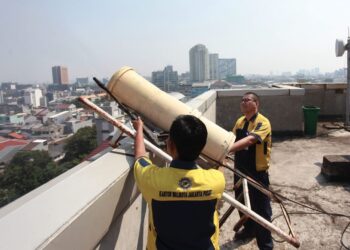 Pekerja menyemprotkan air menggunakan water mist generator di Kantor Walikota, Jakarta Pusat, Jakarta, Selasa (5/9/2023). Pemerintah Provinsi DKI Jakarta melakukan uji coba pompa bertekanan tinggi (water mist generator) untuk mengatasi menekan polusi udara di Jakarta. ANTARA FOTO/Reno Esnir/YU