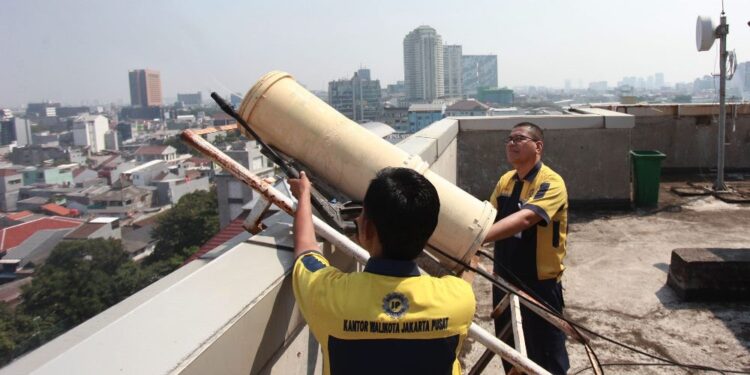 Pekerja menyemprotkan air menggunakan water mist generator di Kantor Walikota, Jakarta Pusat, Jakarta, Selasa (5/9/2023). Pemerintah Provinsi DKI Jakarta melakukan uji coba pompa bertekanan tinggi (water mist generator) untuk mengatasi menekan polusi udara di Jakarta. ANTARA FOTO/Reno Esnir/YU