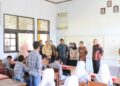 Foto: Sekdako Lhokseumawe T. Adnan, Kamis (20/2/2025), meninjau proses pembagian makanan bergizi gratis perdana di Lhokseumawe.