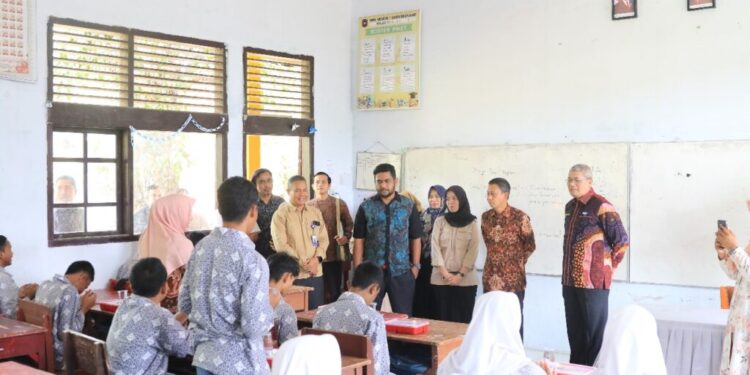 Foto: Sekdako Lhokseumawe T. Adnan, Kamis (20/2/2025), meninjau proses pembagian makanan bergizi gratis perdana di Lhokseumawe.